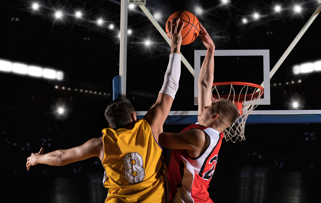 Two basketball players in arena. Blocked shot